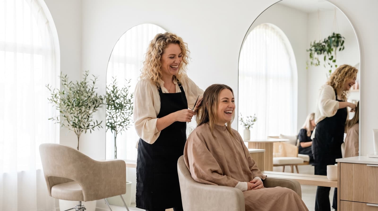 Friseurin frisiert eine zufriedene Kundin in einem hellen Salon